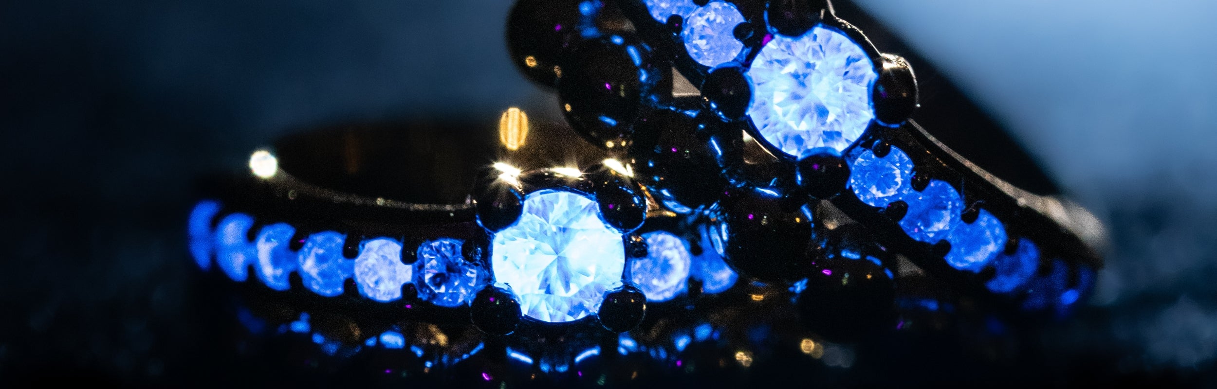 Spirit Earring Peak showing diamonds that glow blue light set in modern electrum