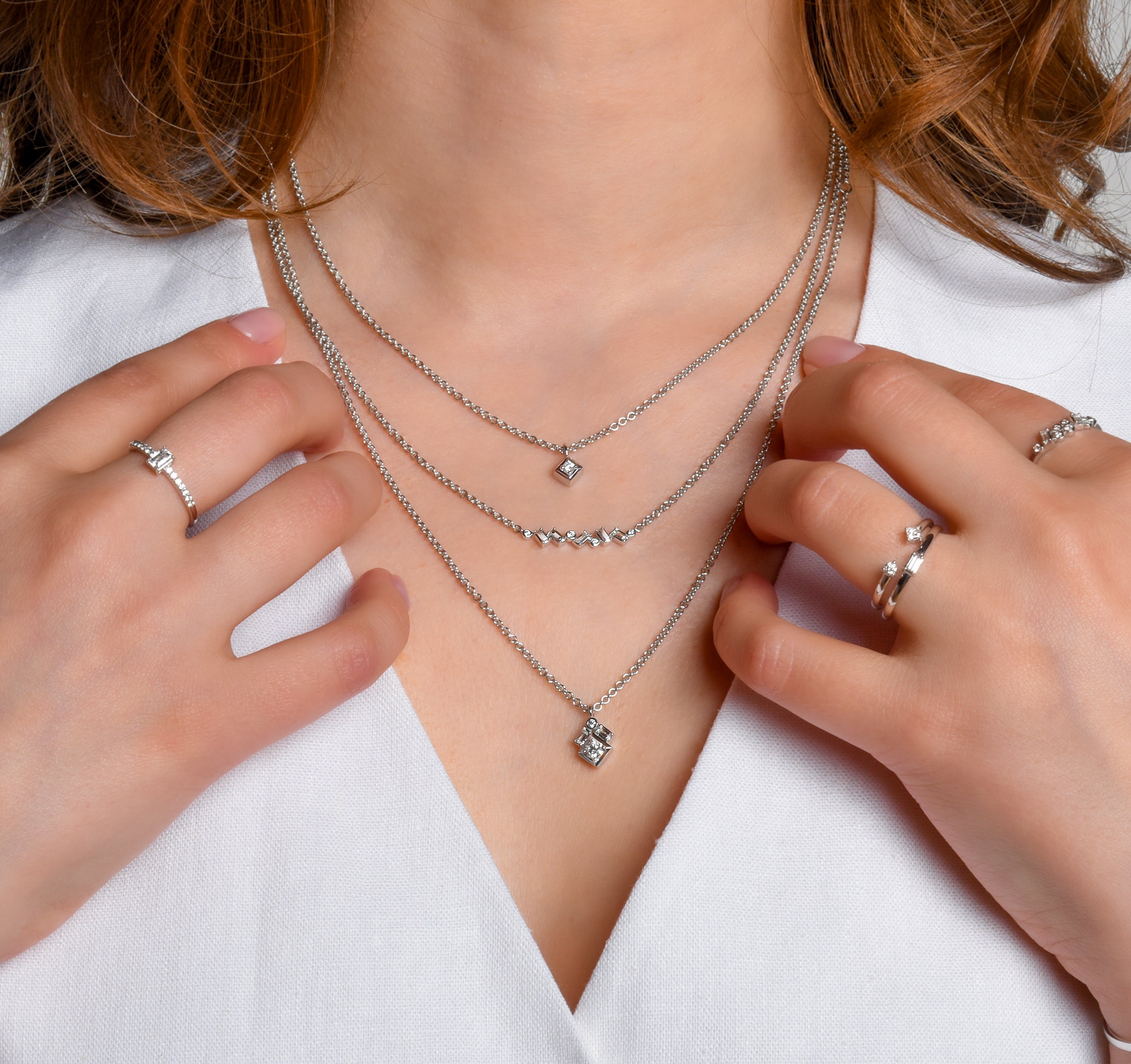 Female model wearing ice collection origin, ascent, summit, and peak earrings, rings, bracelets, and necklaces set in modern electrum.  Diavik natural diamonds.