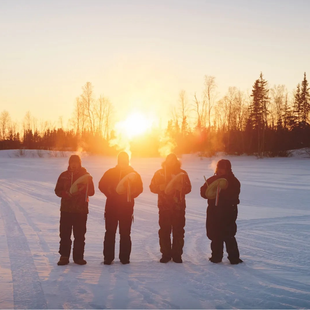 Indigenous People of the Northwest Territories sunset playing drums winter